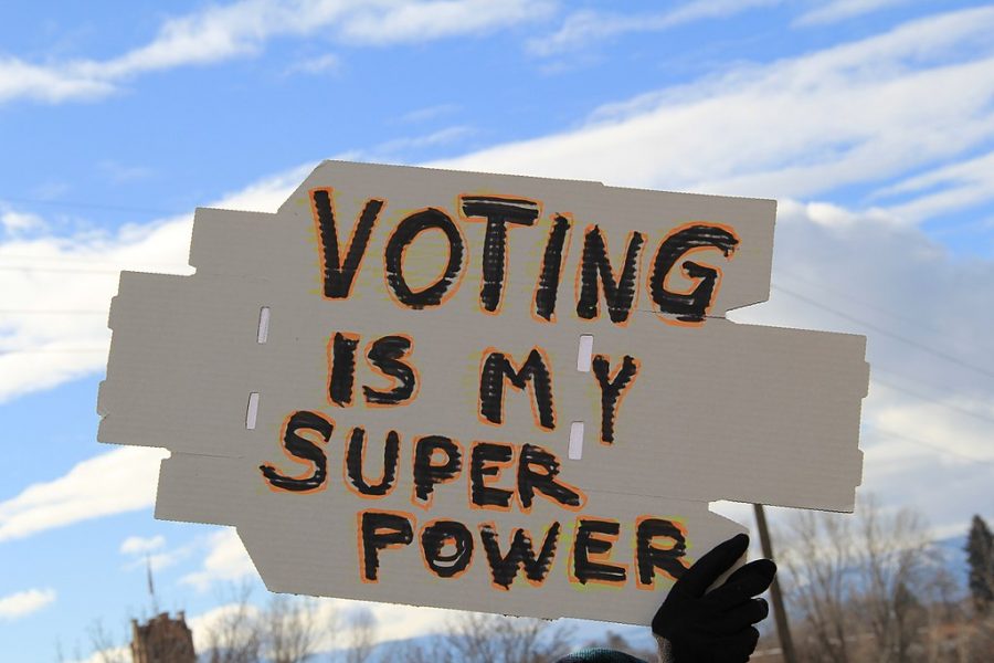 A photograph of a cardboard sign that reads voting is my super power