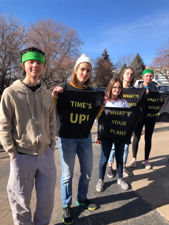 Student members of the Sunrise Movement Club at Boulder hold up protest signs outside the Denver Capitol building on January 9th. 