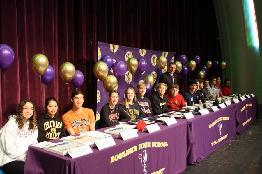 The proud student athletes pose for a photo on the stage in the auditorium after signing.