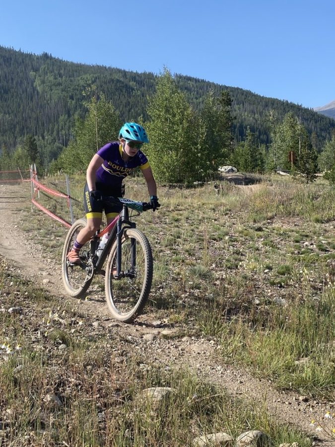 Varsity Girls racer finishes the initial ascent and begins the first downhill on the race course.
