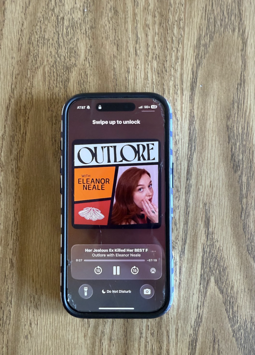 A student's iPhone plays the latest episode of Eleanor Neale's "Outlore" podcast, which details true crime cases, some solved and some unsolved.
